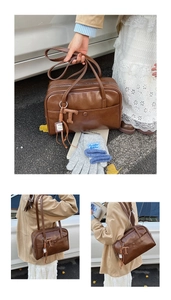 Detail of vintage brown leather Boston bag with fashion pendant and tassel accents