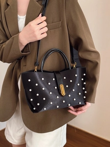Elegante borsa in pelle nera con rivetti in perla e chiusura a scatto in oro ovale