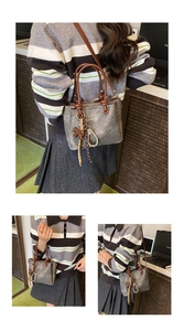 Detail view of a grey bucket bag with brown handles and decorative pearl charms