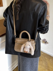 Sac à bandoulière tendance en cuir kaki avec charme lapin porté par un mannequin