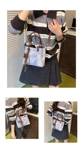Detailed views of light blue marble print bucket bag with dark brown handles and bow
