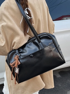 Large black leather underarm tote bag with vintage minimalist design and tassel detail