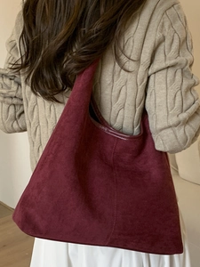 Grand sac hobo rétro bordeaux en daim pour femme porté avec un pull d'hiver chaud