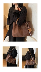 Detailaufnahme der braunen Wildleder-Tragetasche mit Bärenanhänger und Mode-Schriftzug