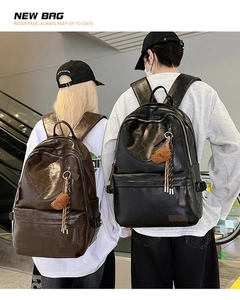 Close-up of brown and black large capacity faux leather backpacks with plush charm