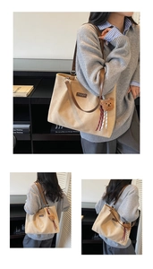 Detailansicht der großen beige Tragetasche mit braunem Gurt und Bärenanhänger