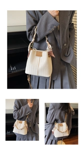 Detail of cream woven bucket bag featuring silk scarf wrapped around a chain handle