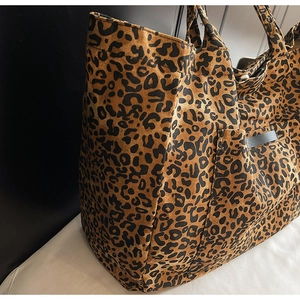 Detailed side pocket view of leopard print canvas tote bag with grey trim accents