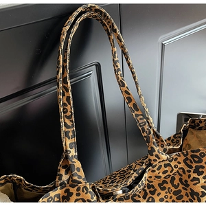 Close-up of leopard print canvas tote bag showing handle stitching and fabric texture
