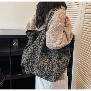 Detail of oversized leopard print tote bag styled with a warm autumn knit sweater