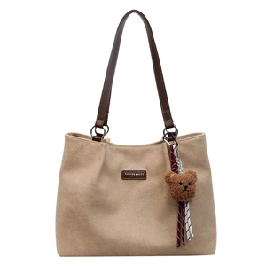 Minimalistische beige Wildleder-Tragetasche mit Lederriemen und Plüschbär-Anhänger