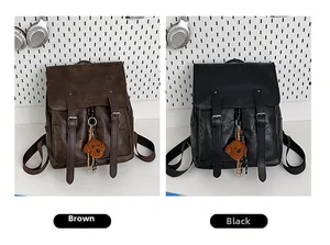 Dettaglio degli zaini vintage in pelle PU marrone e nera con ciondoli a forma di orso