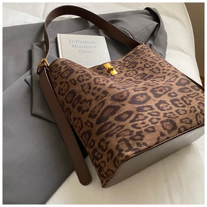 Detail of leopard print tote bag with gold metal clasp and brown leather strap