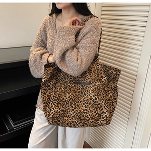 Detailed shot of large capacity leopard print tote bag styled with casual knitwear