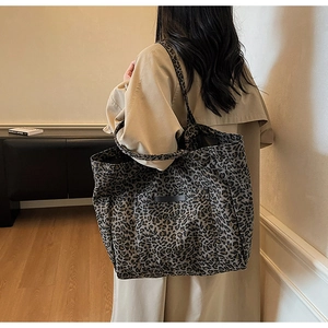Detail of leopard print canvas tote bag on trench coat with spacious pocket and retro style