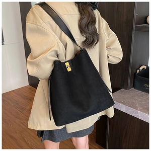 Detail of a black matte bucket bag featuring a square gold buckle and wide leather strap