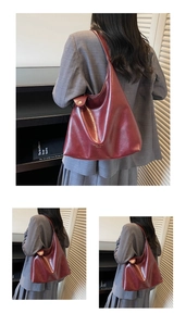 Detail view of burgundy minimalist shoulder bucket bag with gold branding text