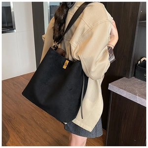 Detail of black matte tote bag with golden twist lock and leather shoulder strap