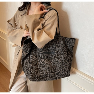 Fashionable leopard print canvas tote bag styled with a khaki trench coat and white trousers