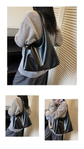 Detail of glossy black leather Hobo shoulder bag with metallic buttons and gold logo