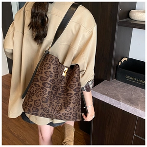 Detail of trendy leopard print tote bag with golden metal twist lock and black strap