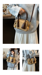 Detail view of vintage-style matte Boston bag with beaded charm and adjustable strap