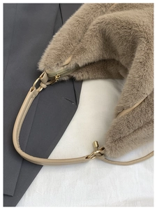 Détail du sac cabas en fausse fourrure beige montrant la texture douce et la boucle en métal