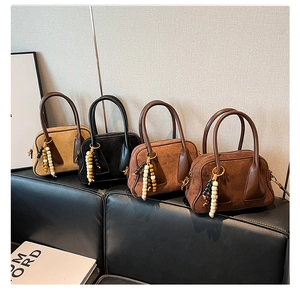 Detail of Boston bags in four earthy colors with matte finish and beaded charms