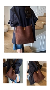 Detail view of brown suede bucket bag with gold metal buckle and adjustable strap