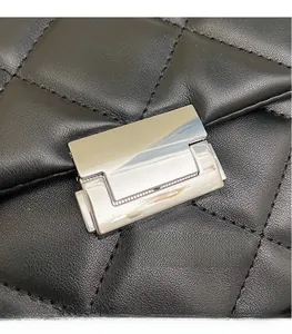 Detailed macro view of black quilted leather bag with a polished silver metal lock