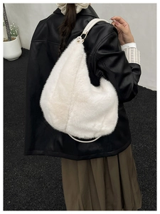 Détail d'un grand sac hobo blanc en fausse fourrure avec bandoulière en cuir et boucles dorées