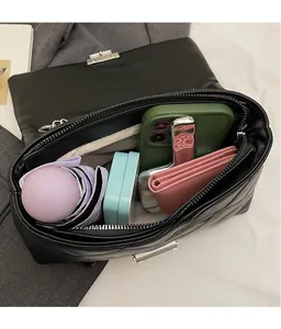Top view of spacious quilted chain bag interior holding a phone, wallet, and umbrella
