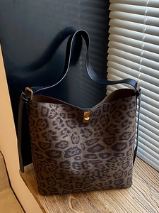 Fashionable leopard print bucket bag with black leather strap and gold metal clasp