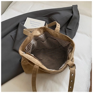 Détail du sac cabas en daim marron avec doublure rayée et poche intérieure pratique