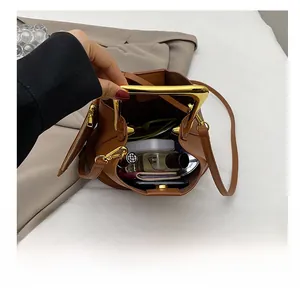 Top view of brown bucket bag interior showing perfume, wallet, and phone capacity