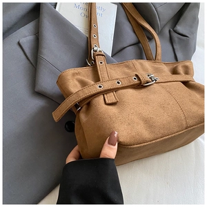 Détail du sac cabas vintage en daim marron avec boucle argentée et œillets décoratifs