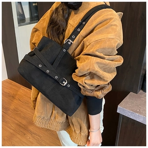 Détails du sac bandoulière vintage en daim avec œillets et large bandoulière