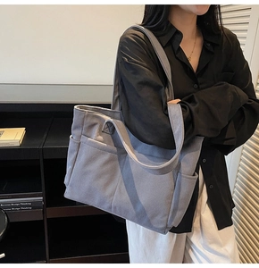 Détail du sac cabas en velours côtelé bleu montrant la poche latérale et l'espace