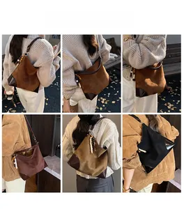 Detail view of suede tote bag featuring ethnic wooden bead charm and leather corner guards
