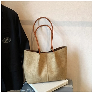 Close-up of woven rhombus texture on large camel faux suede tote bag with slim handles