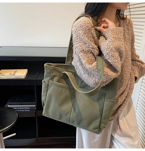 Gros plan sur la texture du cabas en velours côtelé vert olive avec poches latérales