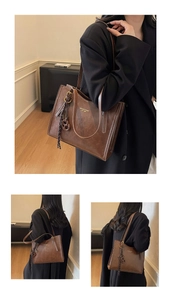 Detailed views of vintage brown tote bag showing gold logo and leather texture on black coat
