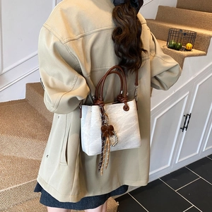 Beige marble texture bucket bag with brown handles and pearl bow detail for women