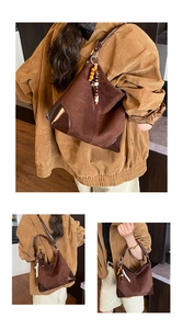 Detailed close-up of retro brown suede handbag with wood bead tassel and glossy leather trim