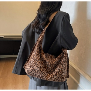 Close-up of high-capacity leopard print hobo bag worn with a professional grey blazer