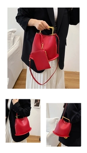 Macro detail of red leather bucket bag with gold U-shaped handle and matching coin purse