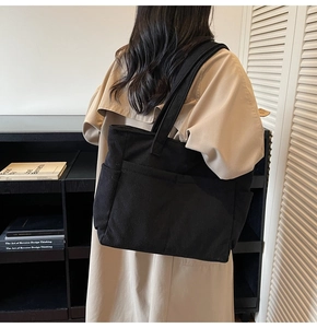Détail du sac cabas en velours côtelé noir montrant la poche latérale et la texture