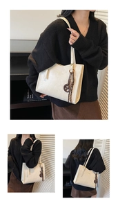 Detail of off-white PU leather tote bag with branded embossing and decorative bow