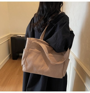 Détail de la texture en velours côtelé et des poches extérieures du sac fourre-tout kaki