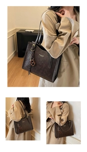 Detail of vintage dark brown tote bag with matte leather texture and gold buckle charm